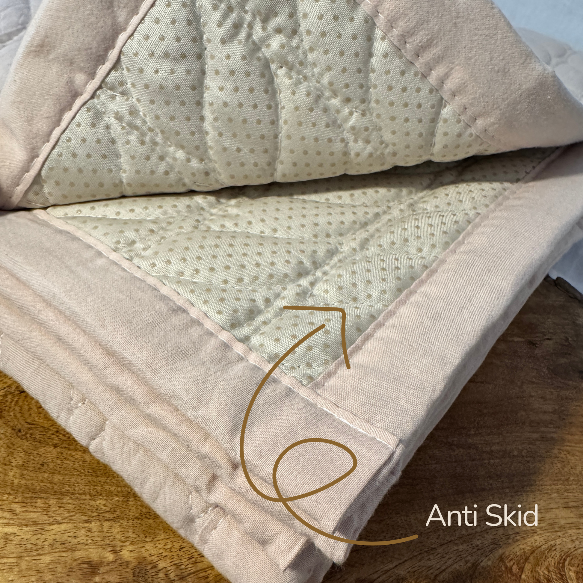 Close-up of a textured blanket with 'Anti Skid' feature on a wooden surface