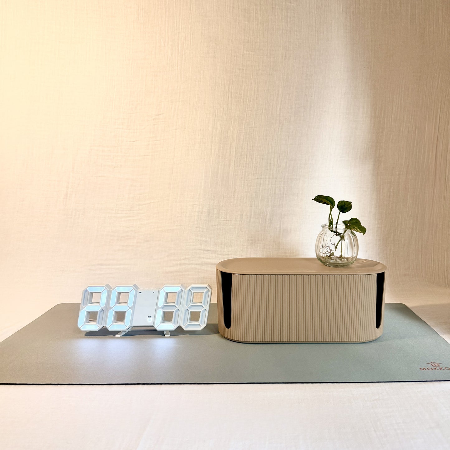 Digital clock, Beige Cable Management box and Green Desk mat with a neutral background