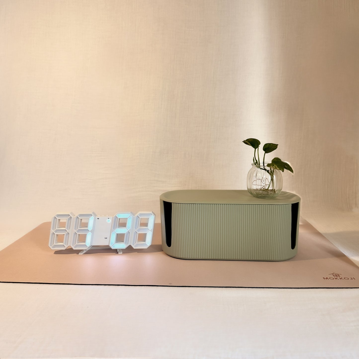 Digital clock, green Cable Management box and Beige Desk mat with a neutral background 
