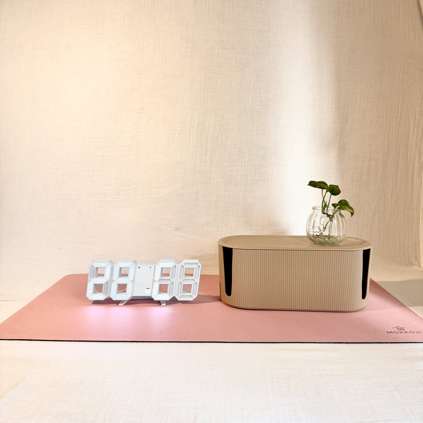 Digital clock, beige Cable Management box and Blush Pink Desk mat with a neutral background