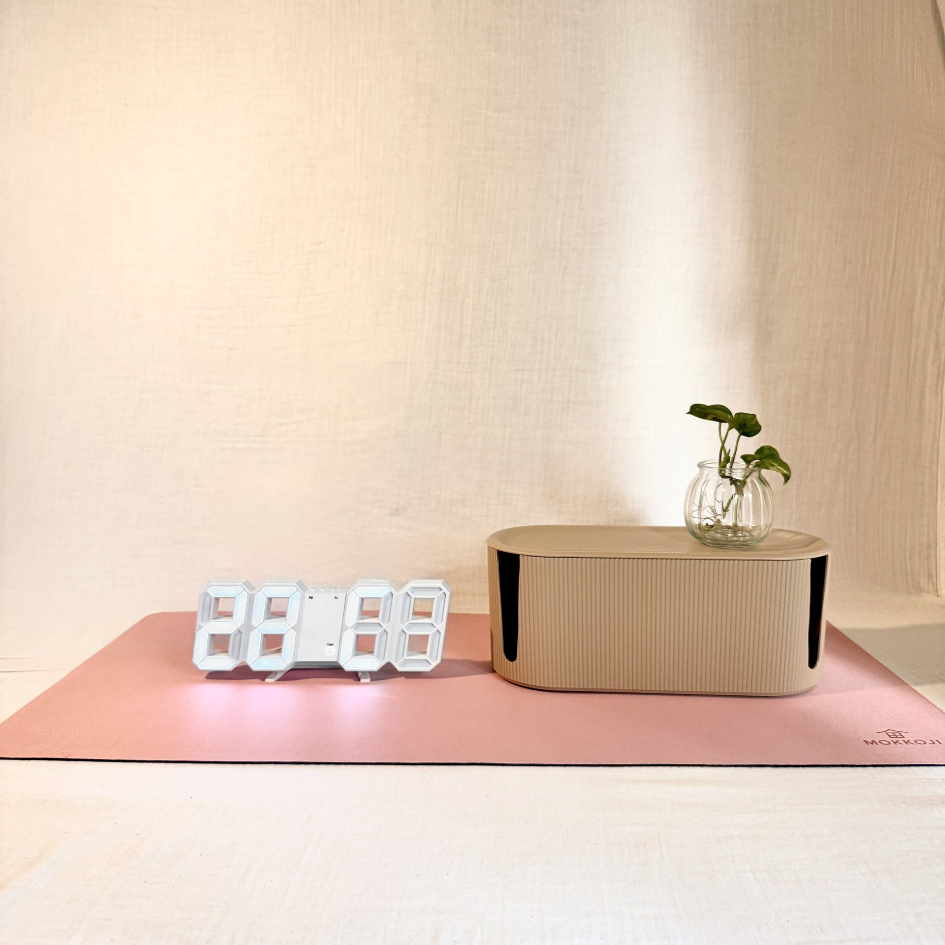 Digital clock, beige Cable Management box and Blush Pink Desk mat with a neutral background
