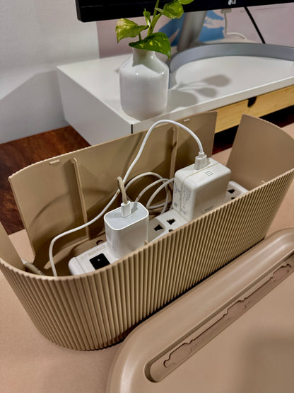 Beige Cable Management box  with multiple outlets and plugs on a desk.